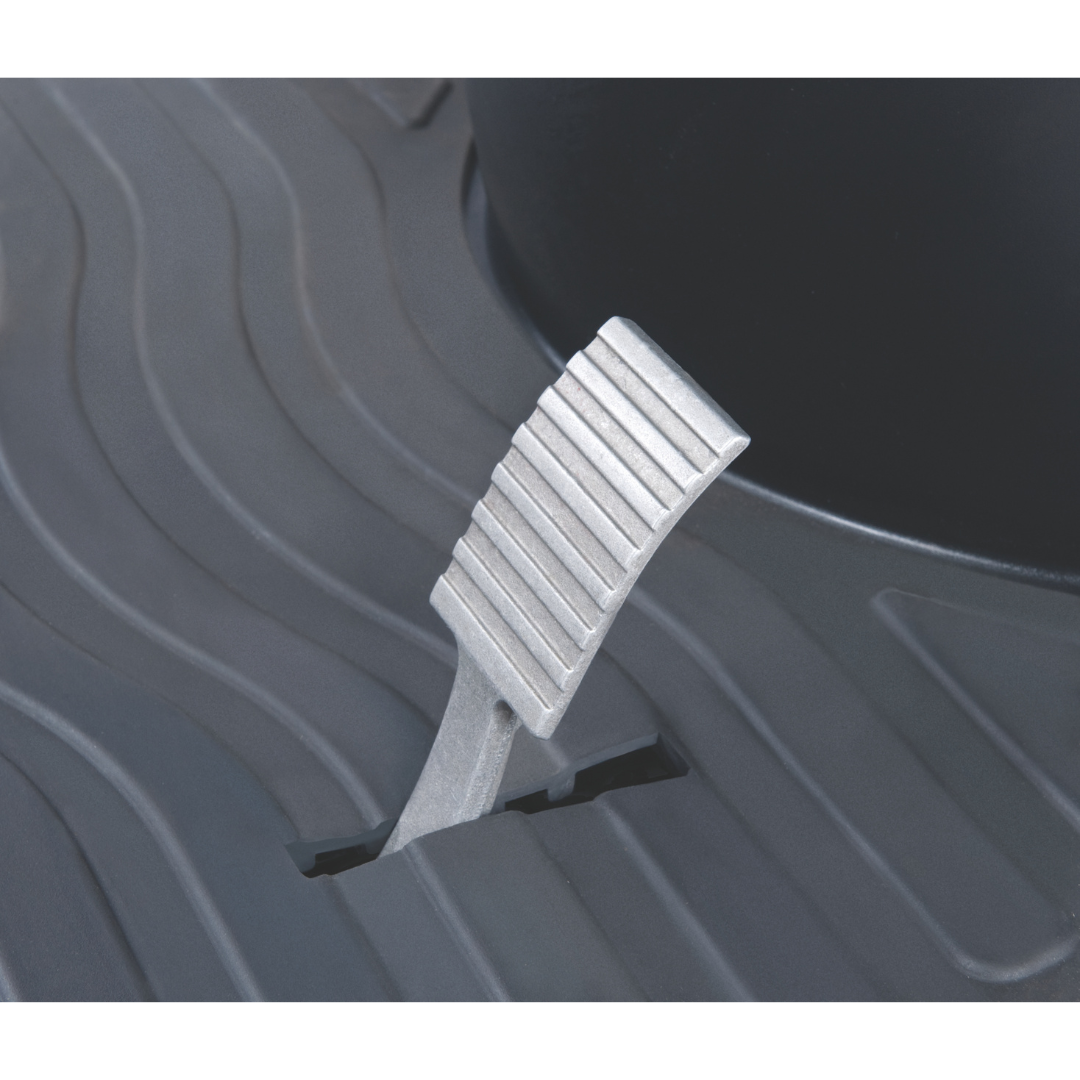 Close-up of a metallic foot pedal with a ribbed texture against a dark, textured background. As an Afikim Electric Vehicle Accessory, the pedal is positioned in a slot, angled upward for potential customization to enhance comfort and safety in your vehicle.